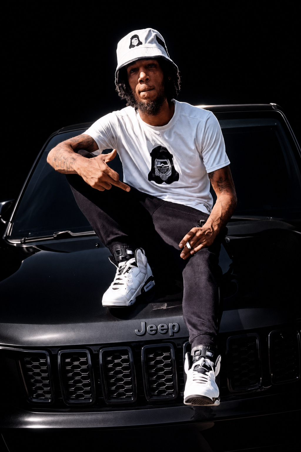 E4R model in white bucket hat and tee sitting on a blacked-out Jeep